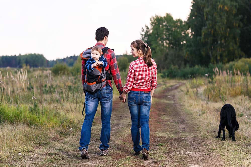 family hiking with a toddler in a back carrier