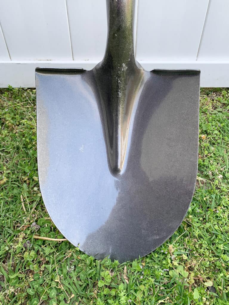 The head of a new digging shovel with a classic rounded shape and rolled edge for stepping.