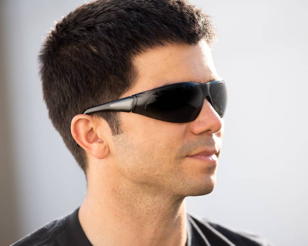 Side profile photo of a man wearing basic tinted safety glasses. 