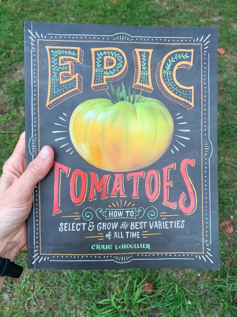 A woman's hand holding the book "Epic Tomatoes"