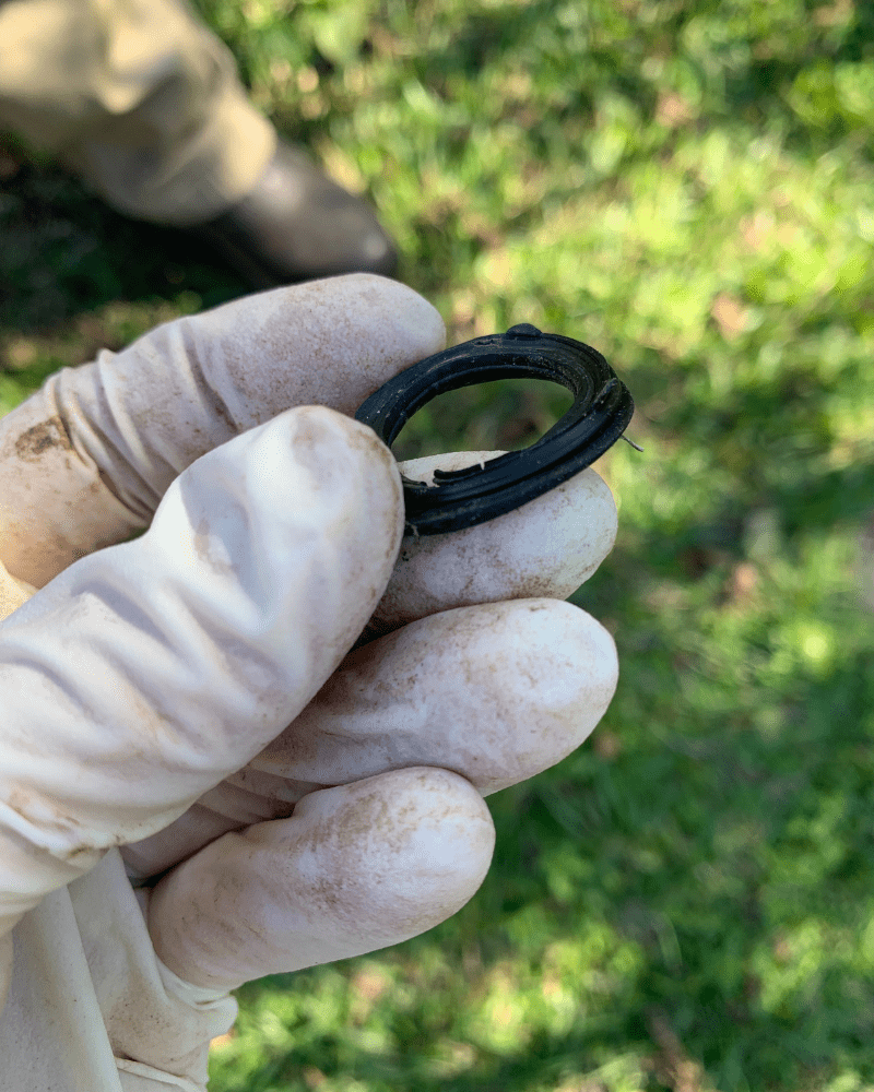 Photo is of a deformed black hose washer with excessive wear.