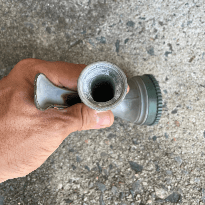 Photo is a view of the underside of a hose nozzle which has some slight corrosion at the inlet and no hose washer.