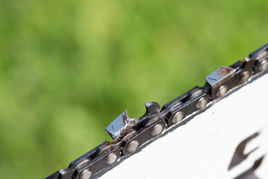 Photo is a close up showing the top of a chainsaw chain after sharpening using a 2 in 1 sharpener. The photo shows the depth gauge has a shiny spot on it showing it has just been filed down.