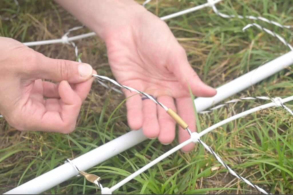 Sliding a brass crimp onto a piece of polywire for fencing