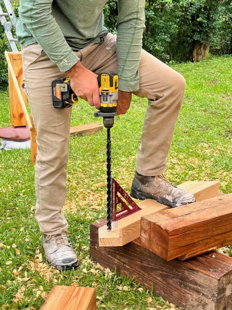 a man using a long auger bit