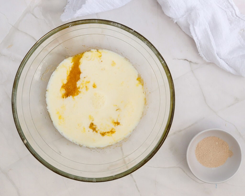 adding milk to a bowl with egg and butter