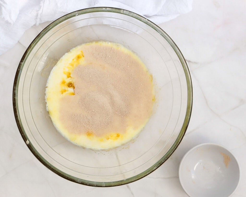 adding yeast to a bowl with warm milk