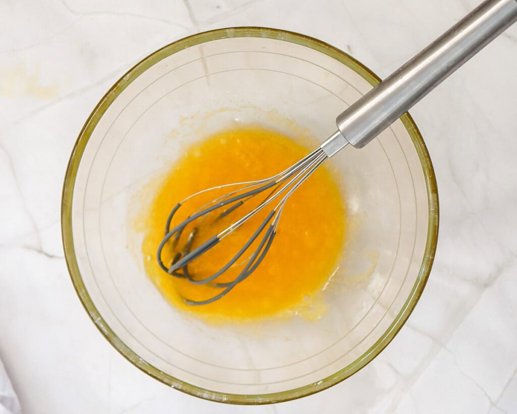 mixing egg and melted butter with a whisk