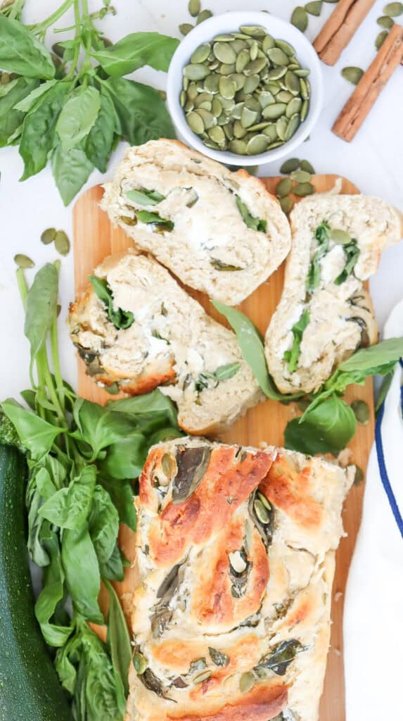 a top down view of a sliced loaf of zucchini swirl bread with pumpkin seeds on top