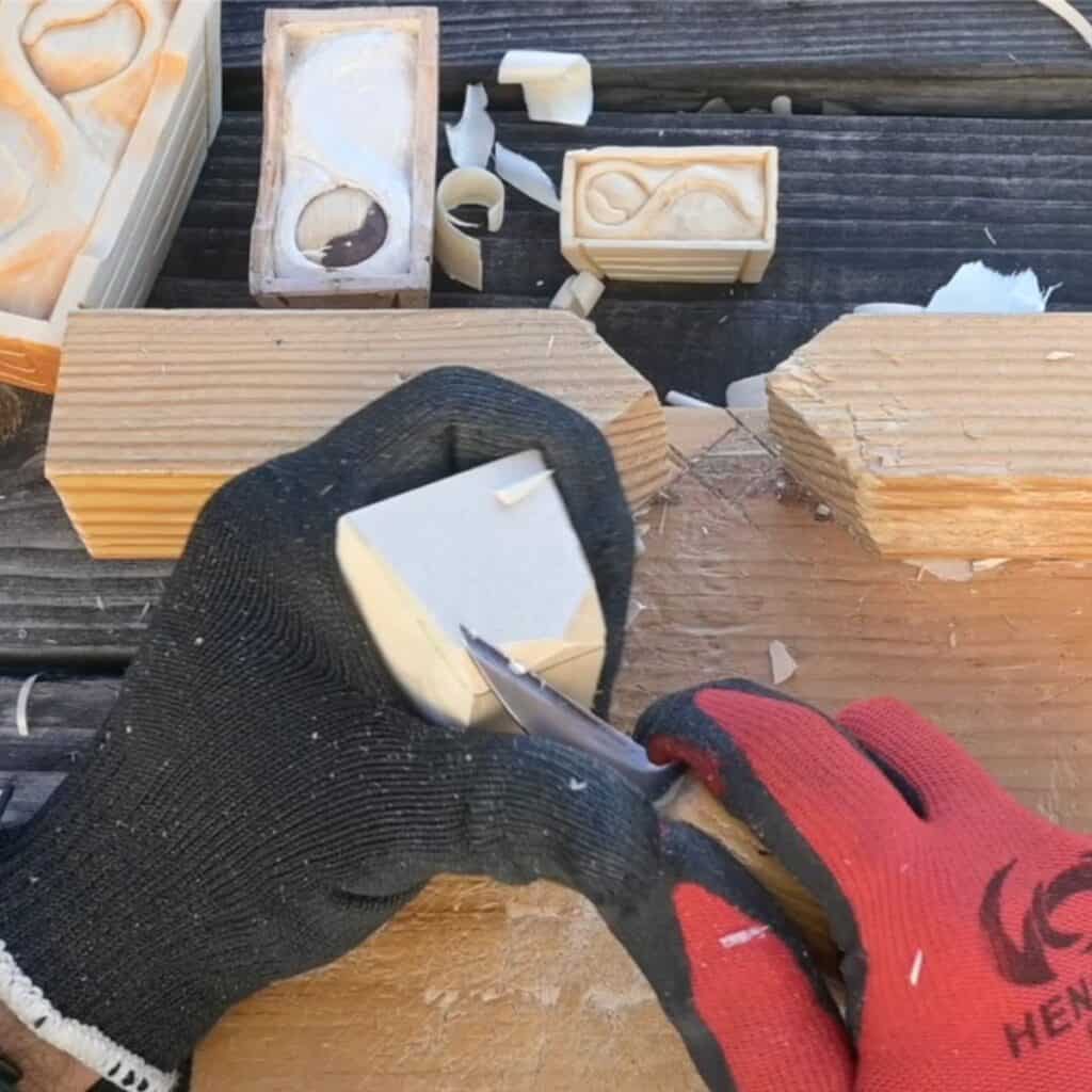 carving the end grain of a block of wood with a knife