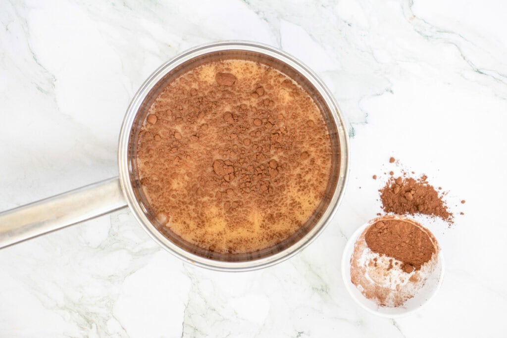 adding spices to milk to make pumpkin hot chocoalte