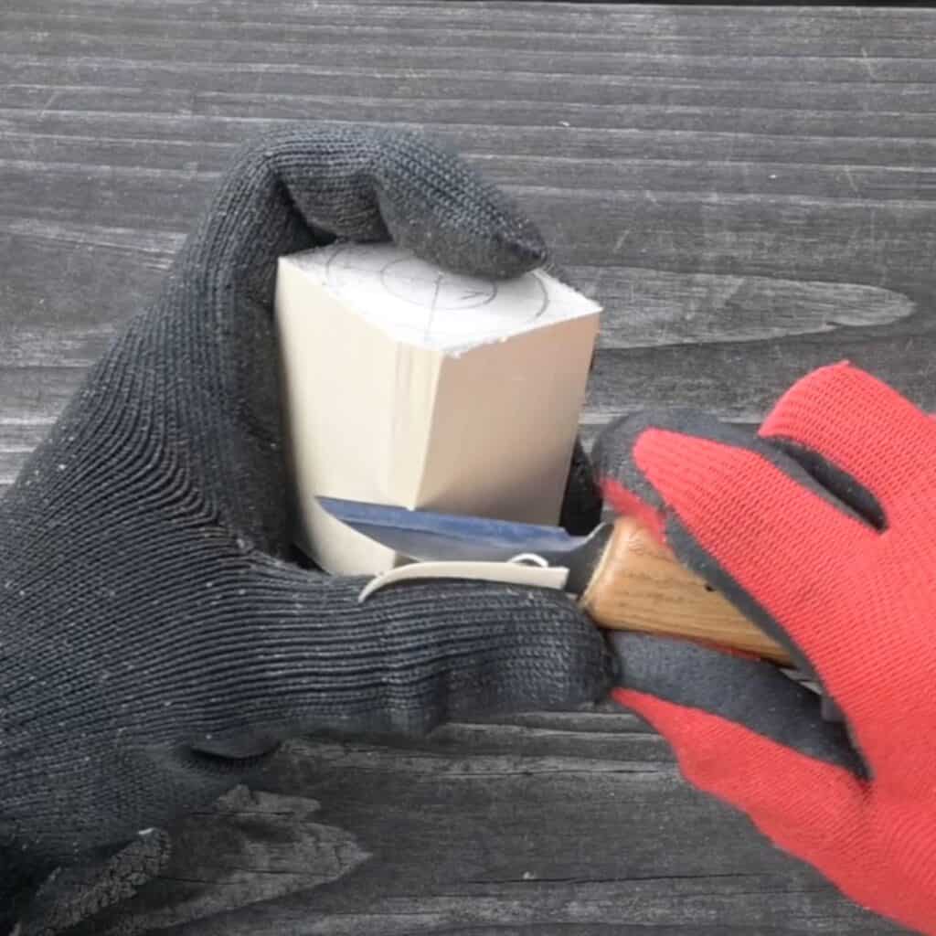 using a roughing knife to cut away at a block of wood