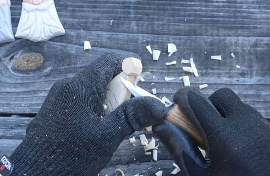 carving the ball on the hat of a wood santa