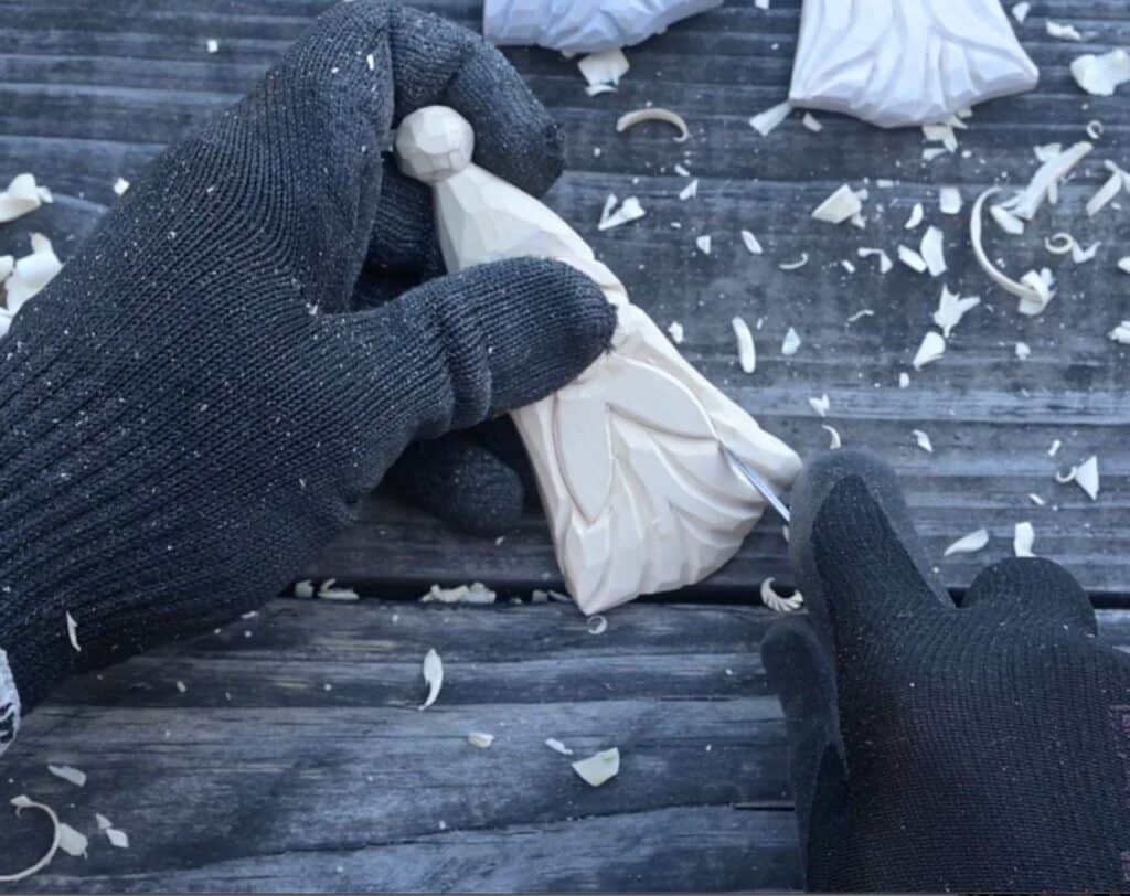 using a knife to carve the beard of a wood santa