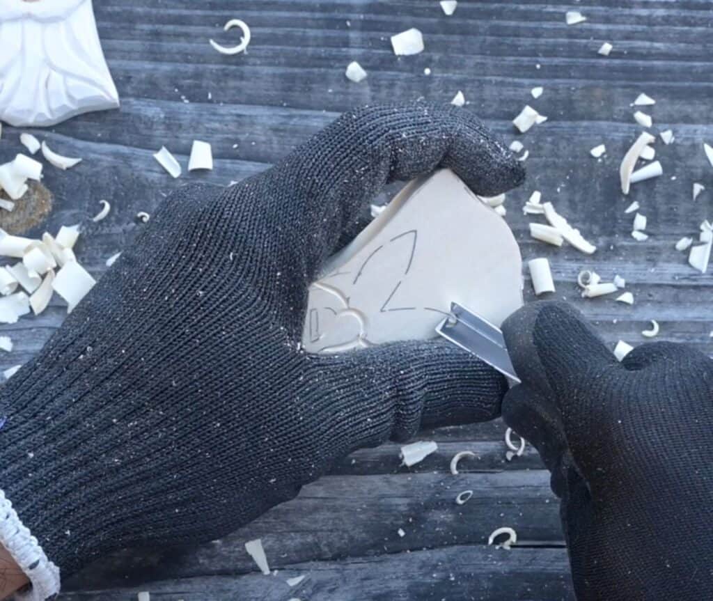 using a v tool to carve the mustache of a wood santa